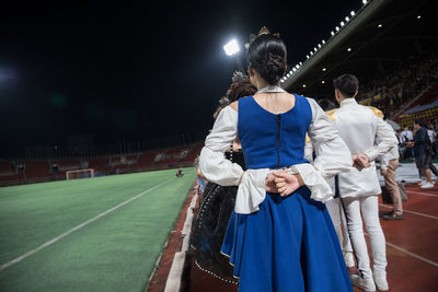 People in illuminated stadium at night