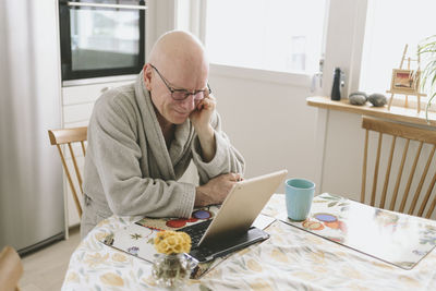 Man sitting at table and having video chat on tablet