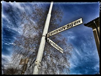 Low angle view of road sign against sky