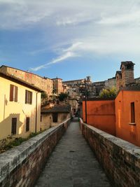 Alley amidst buildings in town against sky