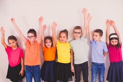 Portrait of friends standing against gray background