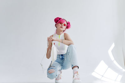 Full length of girl with arms raised standing against white background