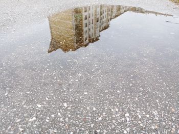 Reflection of buildings in puddle on street