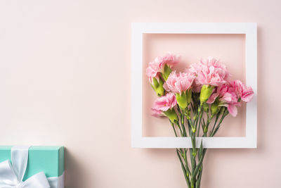 Close-up of pink flower vase against white wall