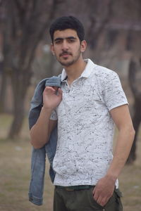 Portrait of young man standing on field