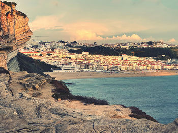 View of city by sea against sky