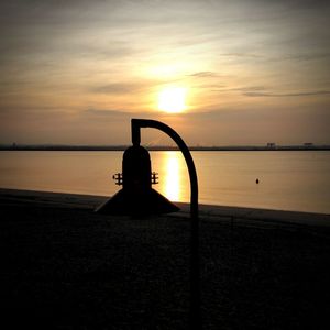 Silhouette of people in sea at sunset