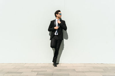 Young man standing against wall