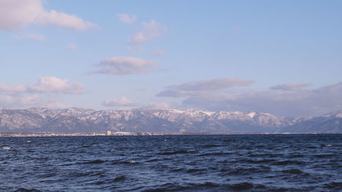 Scenic view of sea and mountains against sky