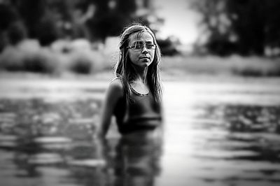 Young woman standing against lake