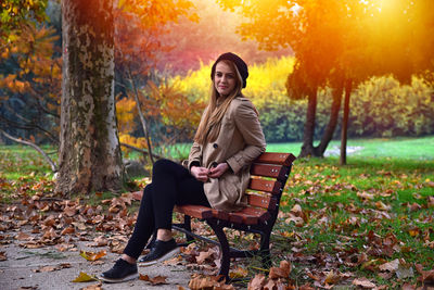 Full length of young woman sitting on field