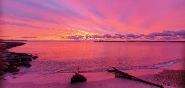 Scenic view of sea against dramatic sky during sunset