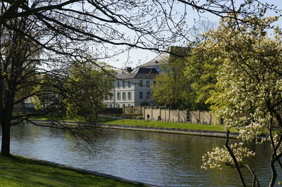 Houses by river against clear sky