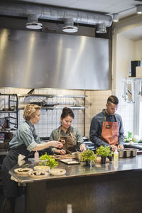 Chefs preparing food on counter in kitchen at restaurant