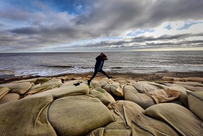 Man standing on beach against sky