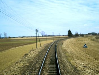 Railroad tracks on field against sky