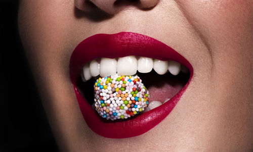 Close-up of multi colored candies in mouth 