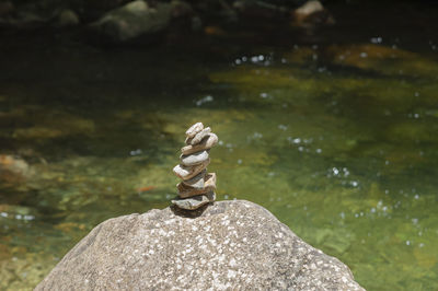 Close-up of stones on rock by lake