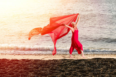 Woman with red umbrella on beach