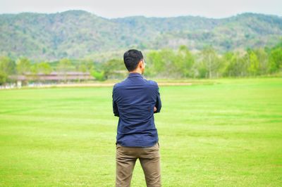 Rear view of man standing on field