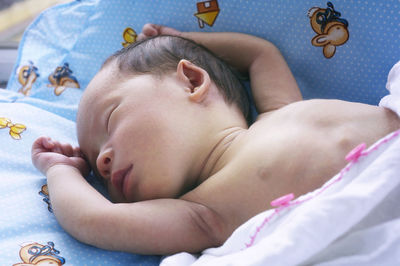 High angle view of baby sleeping on bed at home