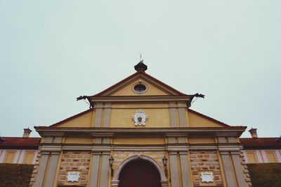 Low angle view of clock tower amidst buildings against sky