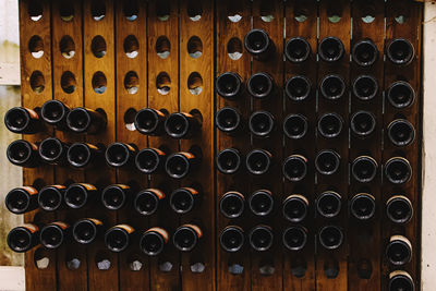 Bottoms of wine bottles in a wooden holder in a wine store