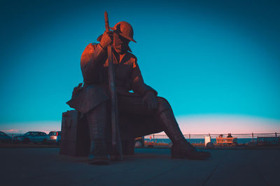 Statue against clear blue sky in city