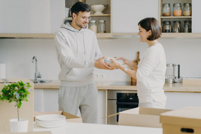 Couple holding plates in kitchen