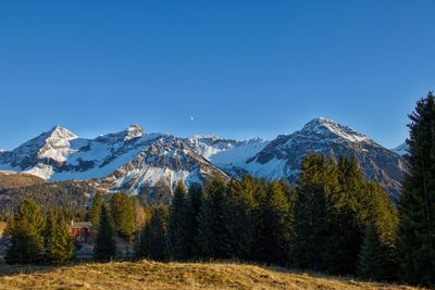 Scenic view of snowcapped mountains against clear blue sky