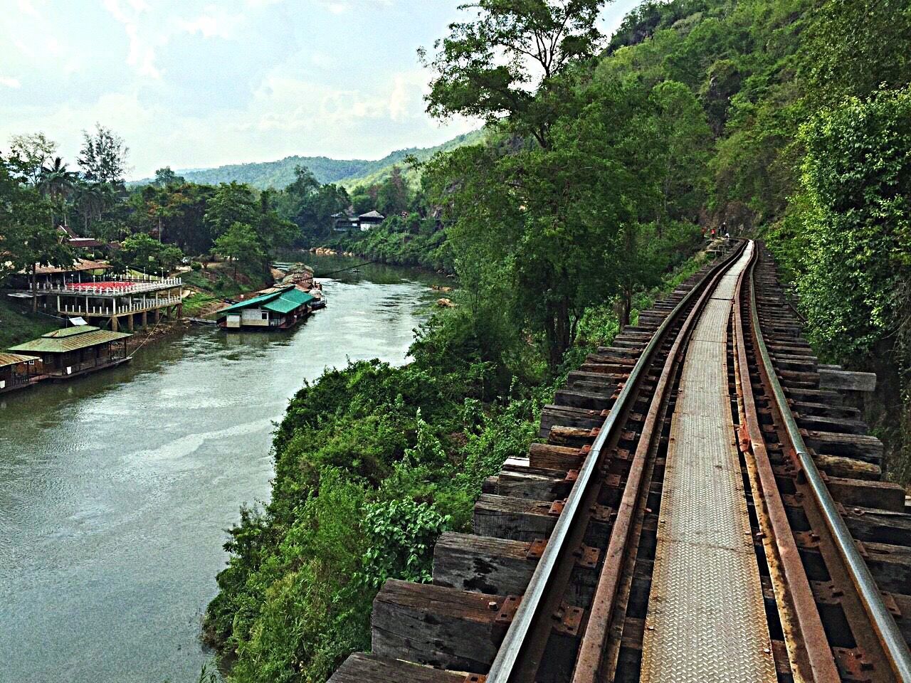 VIEW OF RAILROAD TRACKS BY RIVER AGAINST SKY