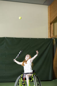 Girl in wheelchair playing tennis