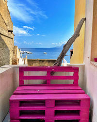 Deck chairs on beach against sky
