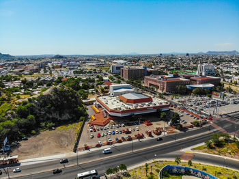 High angle view of vehicles on road by buildings against sky