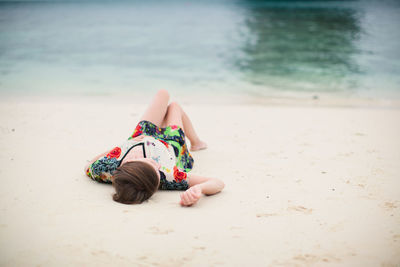 Young woman lying on sand