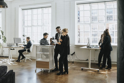 Male and female business colleagues working together at corporate office