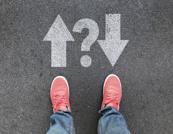 Low section of man standing on road