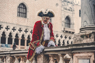 Portrait of man standing against building