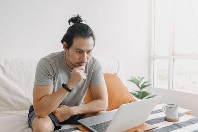 Young man using laptop at home