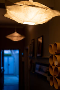 Close-up of electric lamp on table in illuminated room