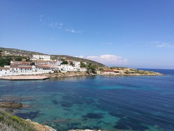 Scenic view of sea by buildings against sky