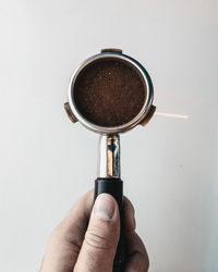 Hand holding coffee cup against white background