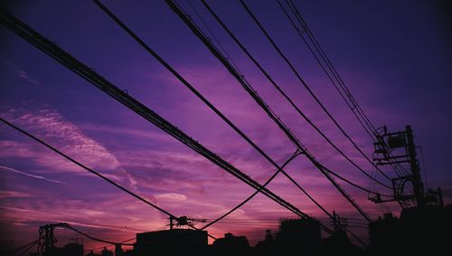 Low angle view of silhouette electricity pylon against sky