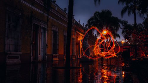 Light painting by building against sky at night