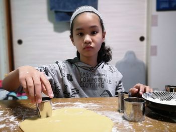 Portrait of young woman preparing food at home