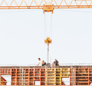 Low angle view of construction site against clear blue sky