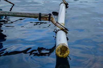 High angle view of chain hanging on railing in lake