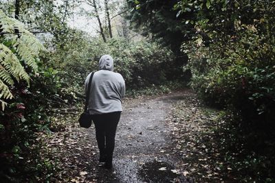 Rear view of man walking on road
