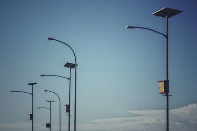 Low angle view of street light against blue sky