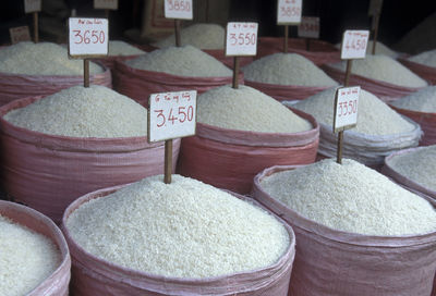 Price tags on heap of rice in sack for sale at market stall
